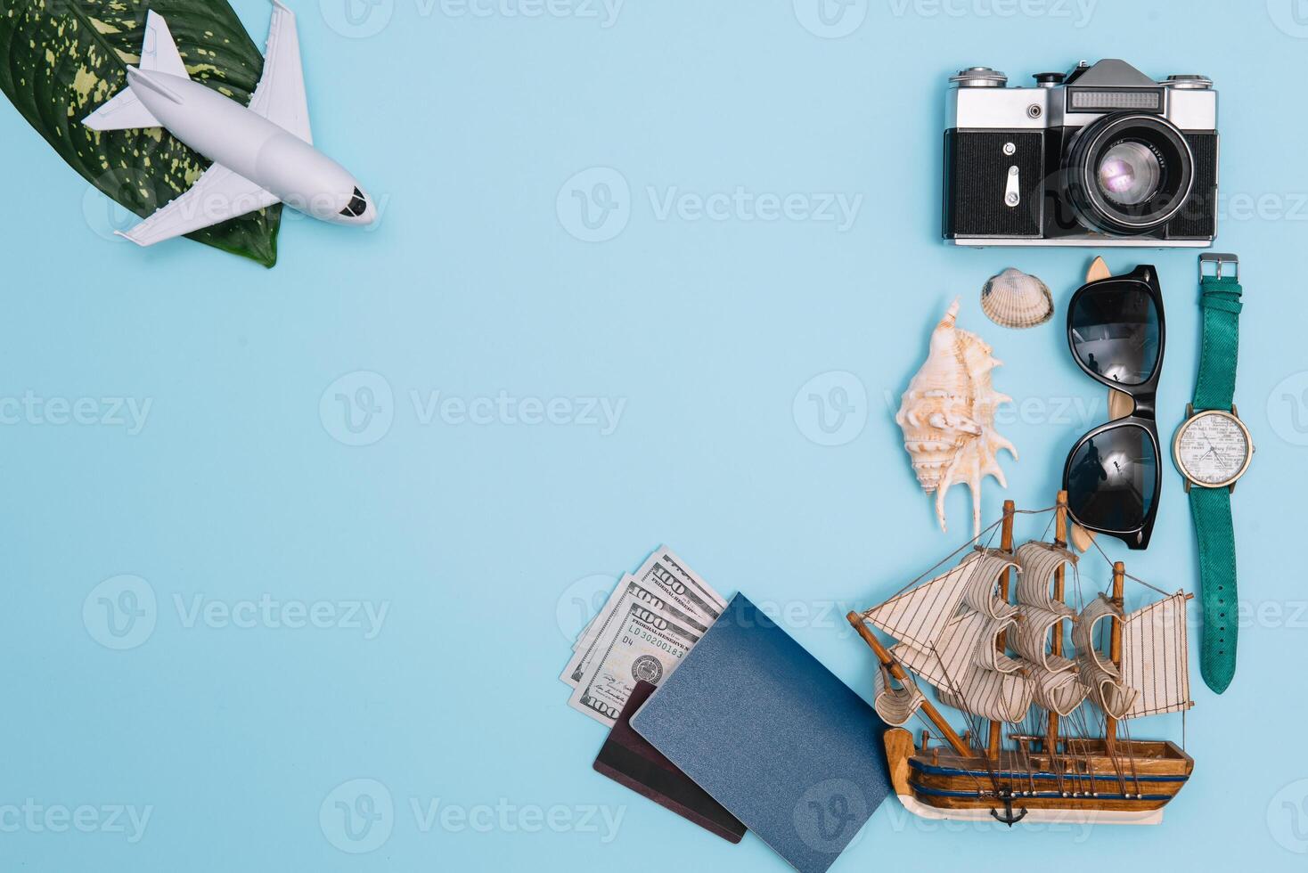 top view travel concept with retro camera films, smartphone, map, passport, compass and Outfit of traveler on blue background with copy space, Tourist essentials, vintage tone effect. photo