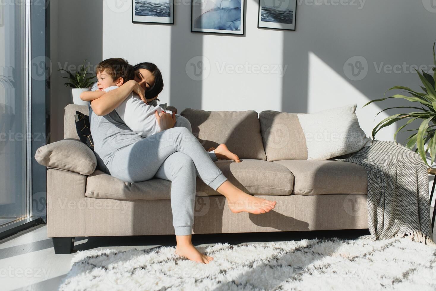 Mother playing with her little cute son in the morning in bedroom. Happy family time. photo