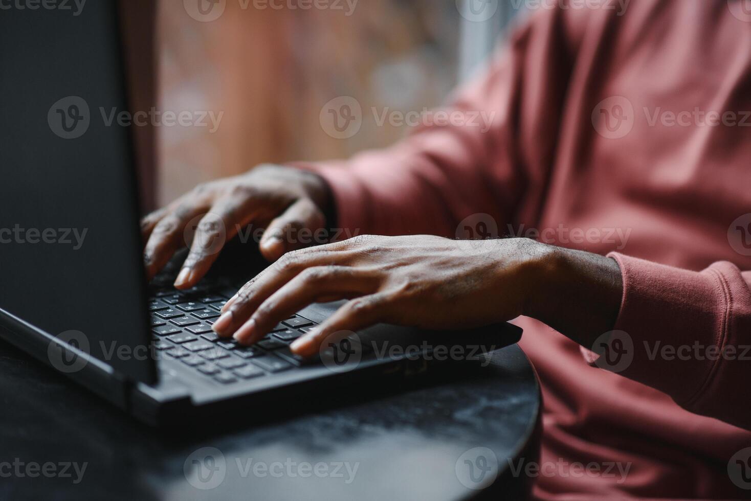 africano americano hombre trabajando en ordenador portátil en un cafetería. foto