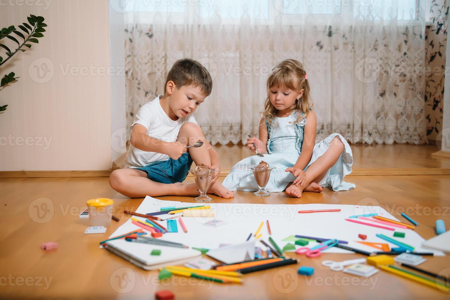 Kids drawing on floor on paper. Preschool boy and girl play on floor with educational toys - blocks, train, railroad, plane. Toys for preschool and kindergarten. Children at home or daycare. photo