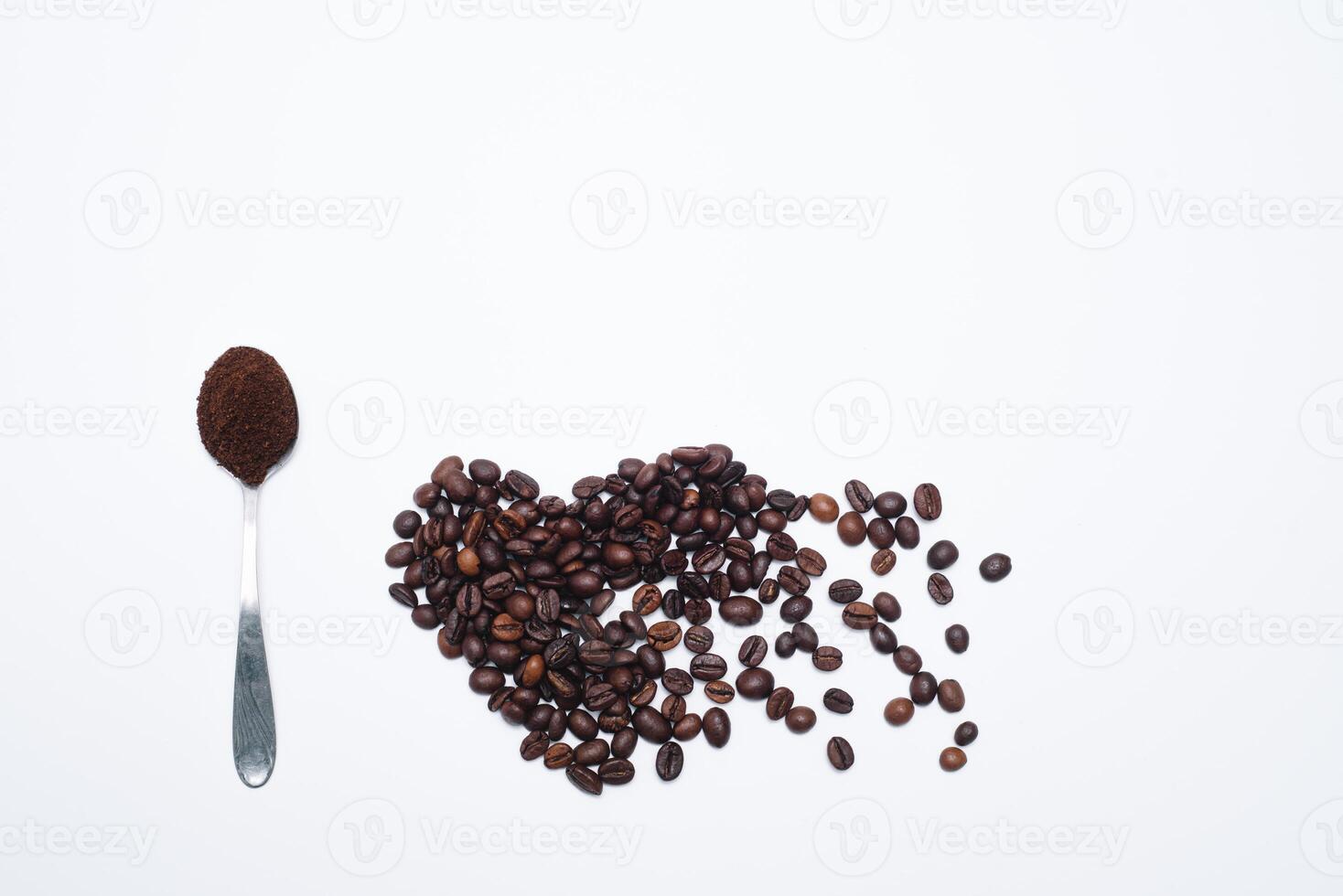 Heart shaped coffee beans with grounds and spoon photo