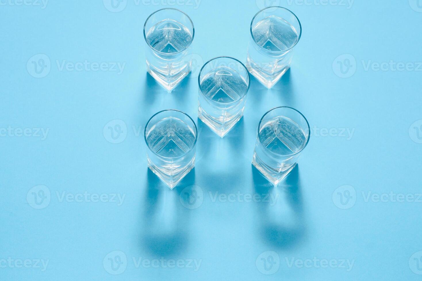 glasses with water on blue background. clean water concept photo