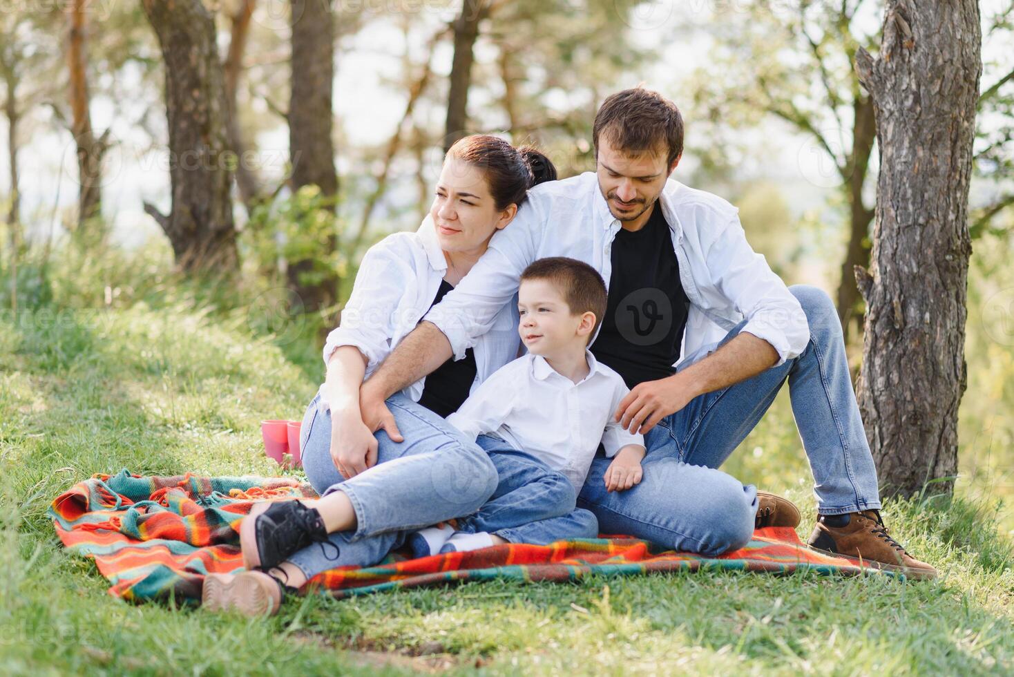 happy young couple with their children have fun at beautiful park outdoor in nature photo