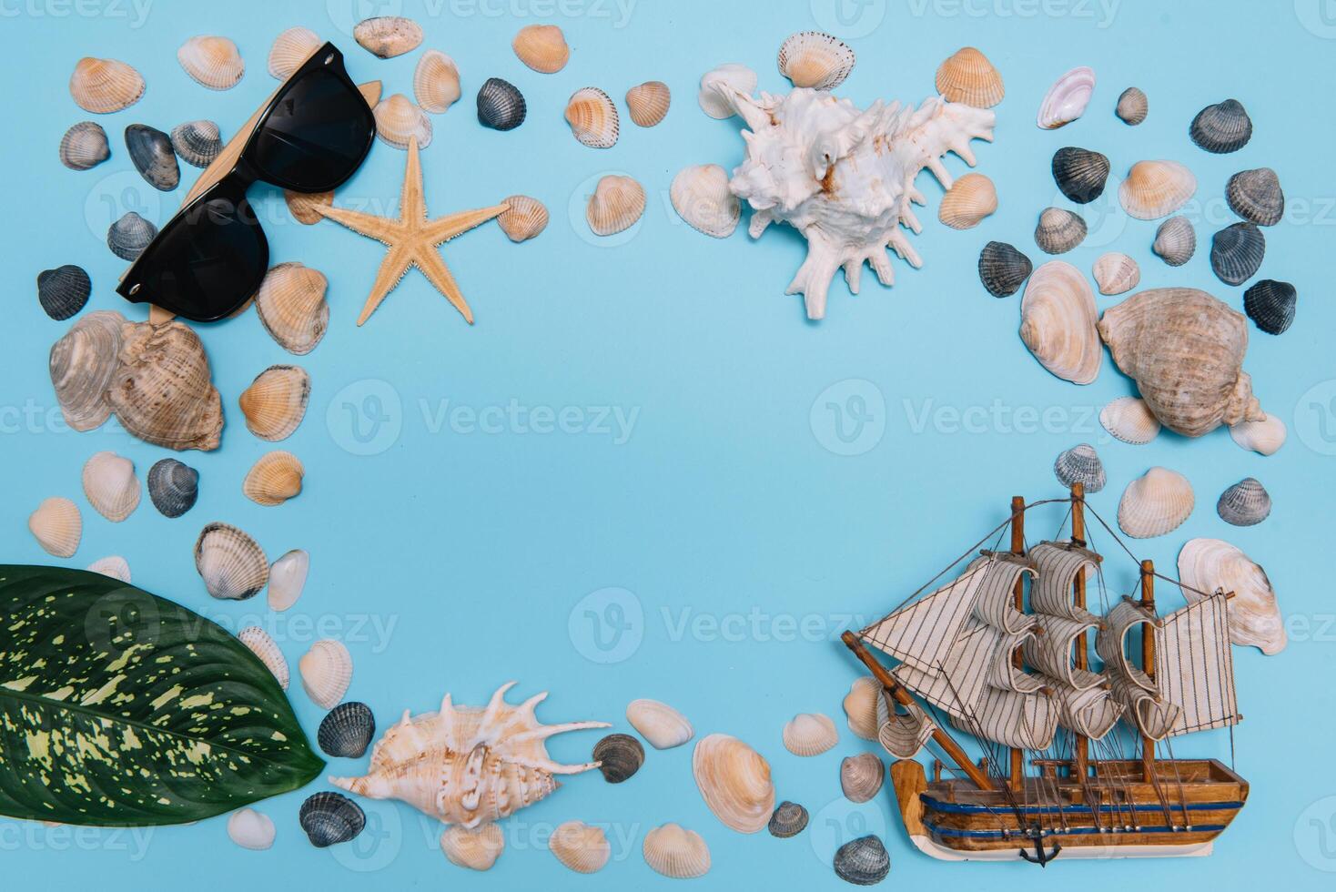 Flat lay. Top view. Frame of shells of various kinds on a blue background. Seashells and starfish and ship on a pastel background. Vacation concept. travel concept. with copy space photo