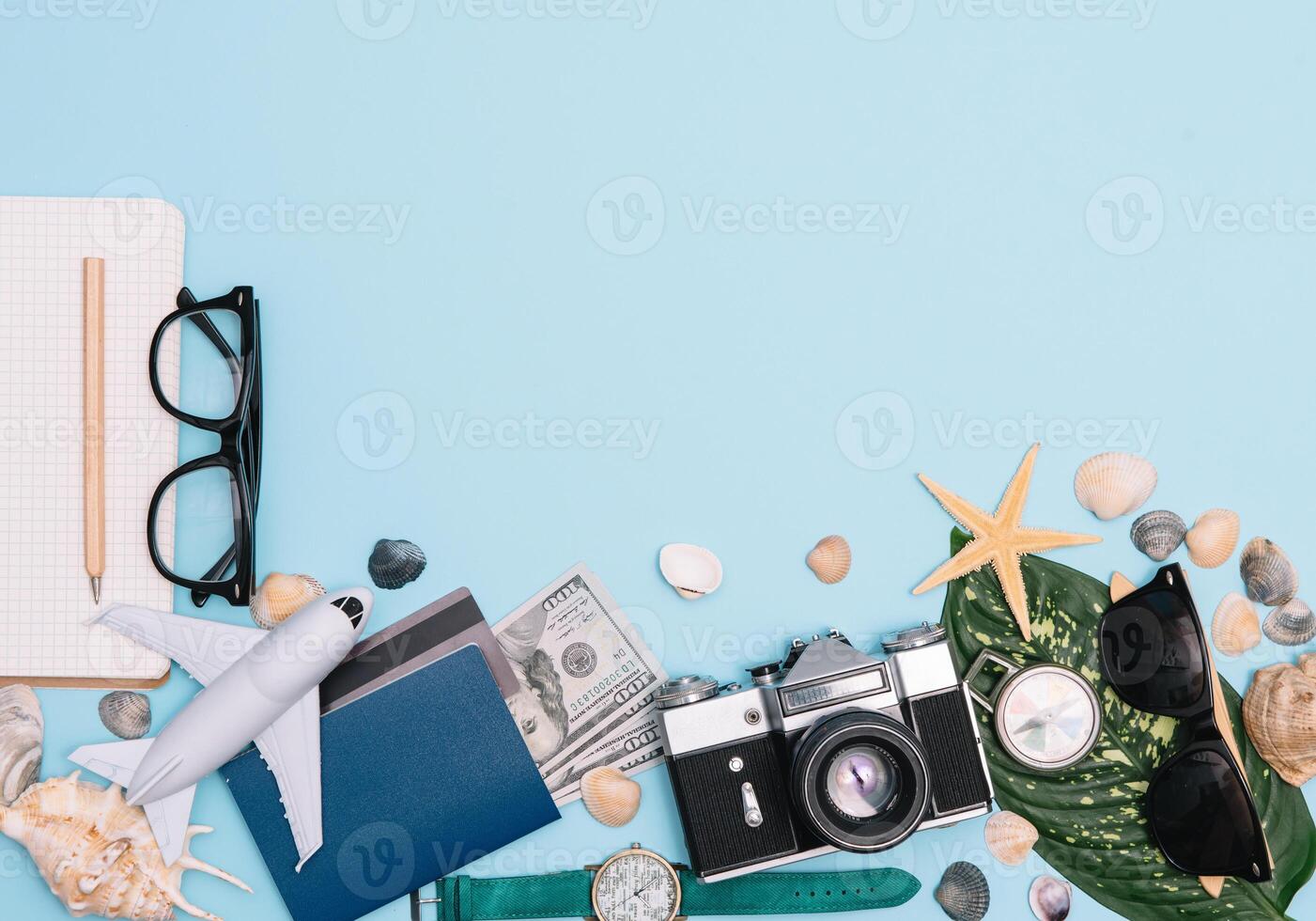 top view travel concept with retro camera films, smartphone, map, passport, compass and Outfit of traveler on blue background with copy space, Tourist essentials, vintage tone effect photo