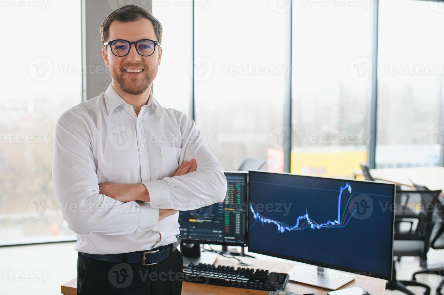 Young bearded man trader at office at table looking camera smiling cheerful photo