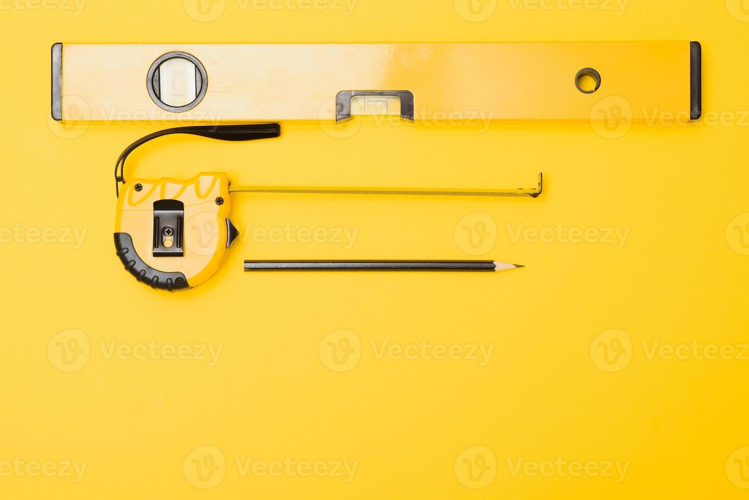 Yellow and black handy tools pilers and screwdriver isolated on yellow background. photo