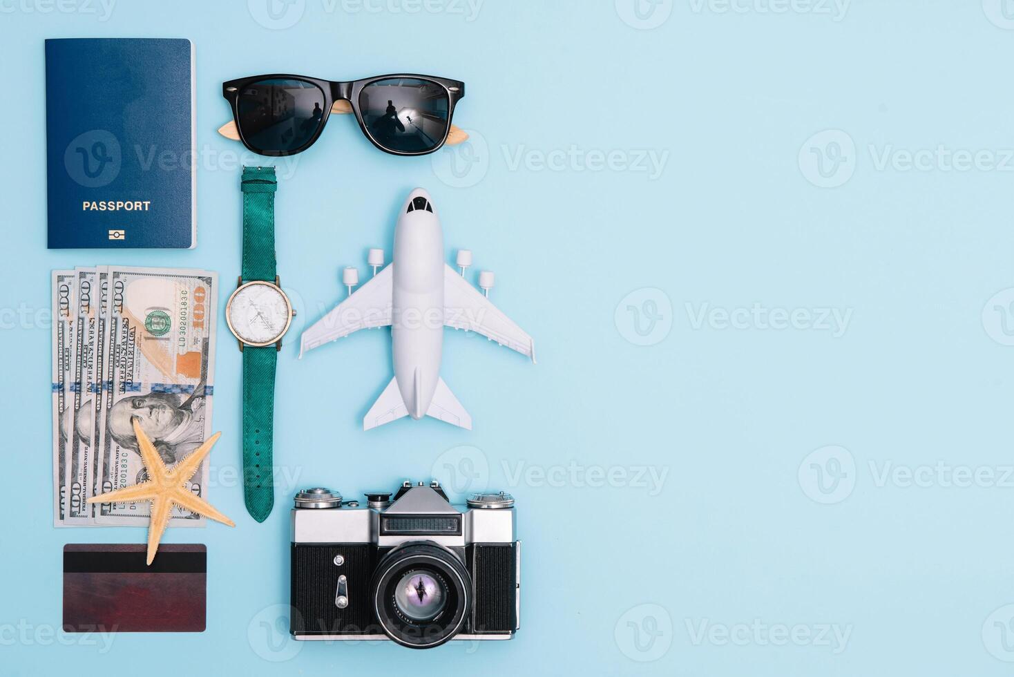 Preparation for Traveling concept, watch, airplane, money, passport, pencils, book, Photo frame, eyeglass on blue background with copy space.