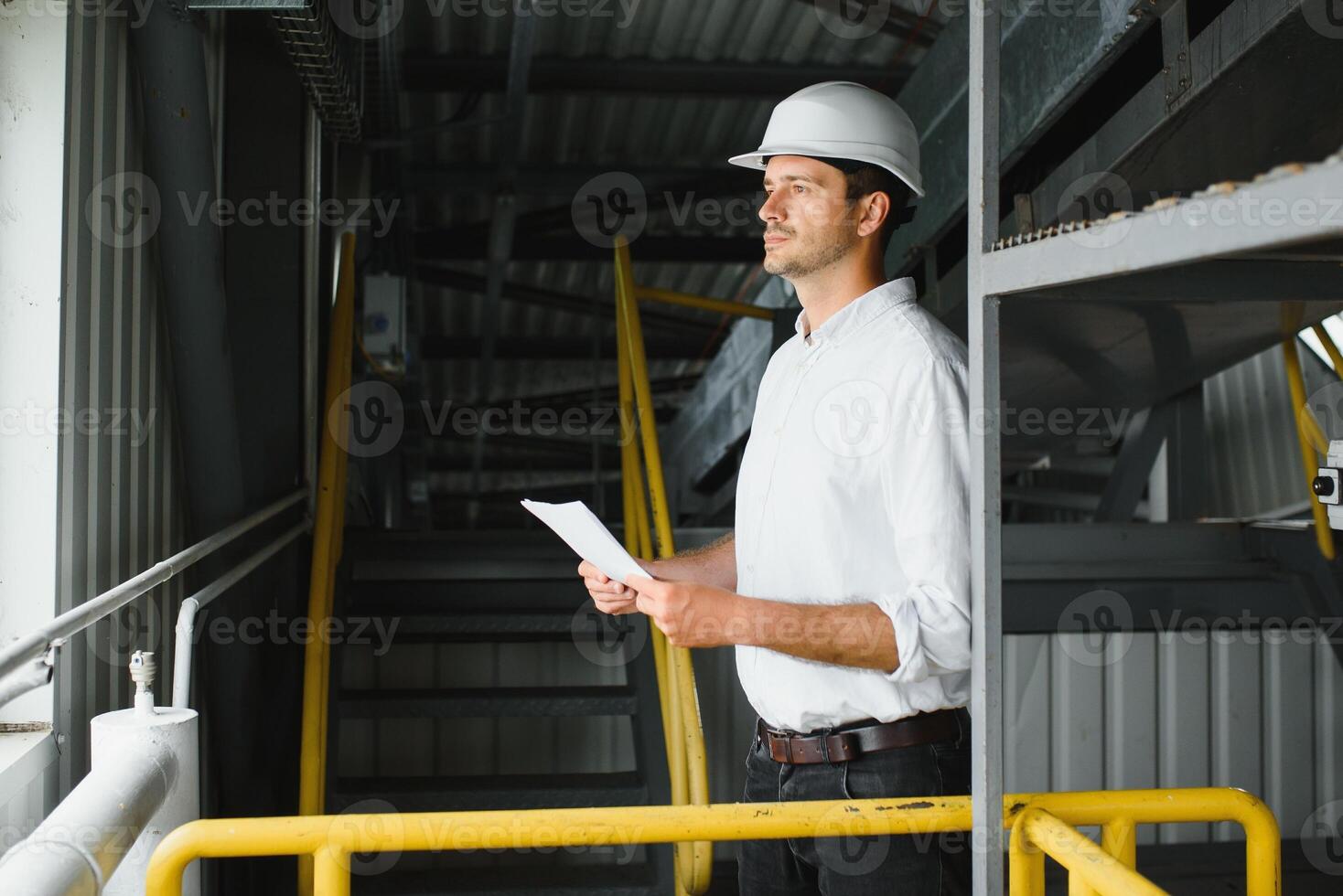 happy male industrial technician inside a factory photo