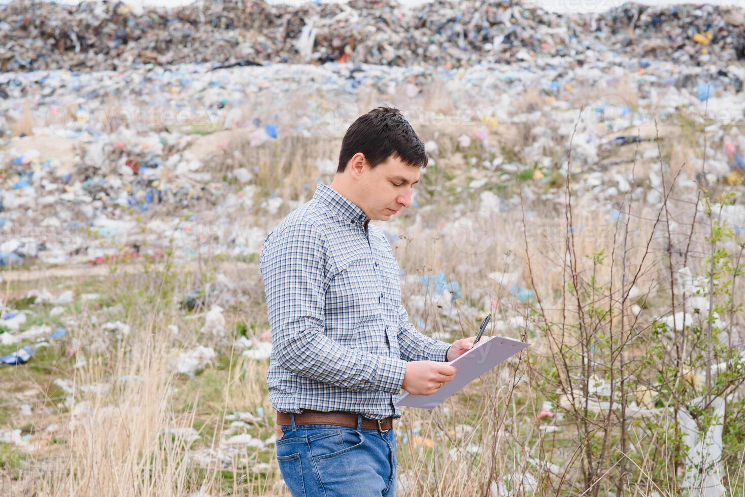 basura reciclaje concepto. hombre en basurero acuerdo el ambiente limpio. ecológico problemas. foto