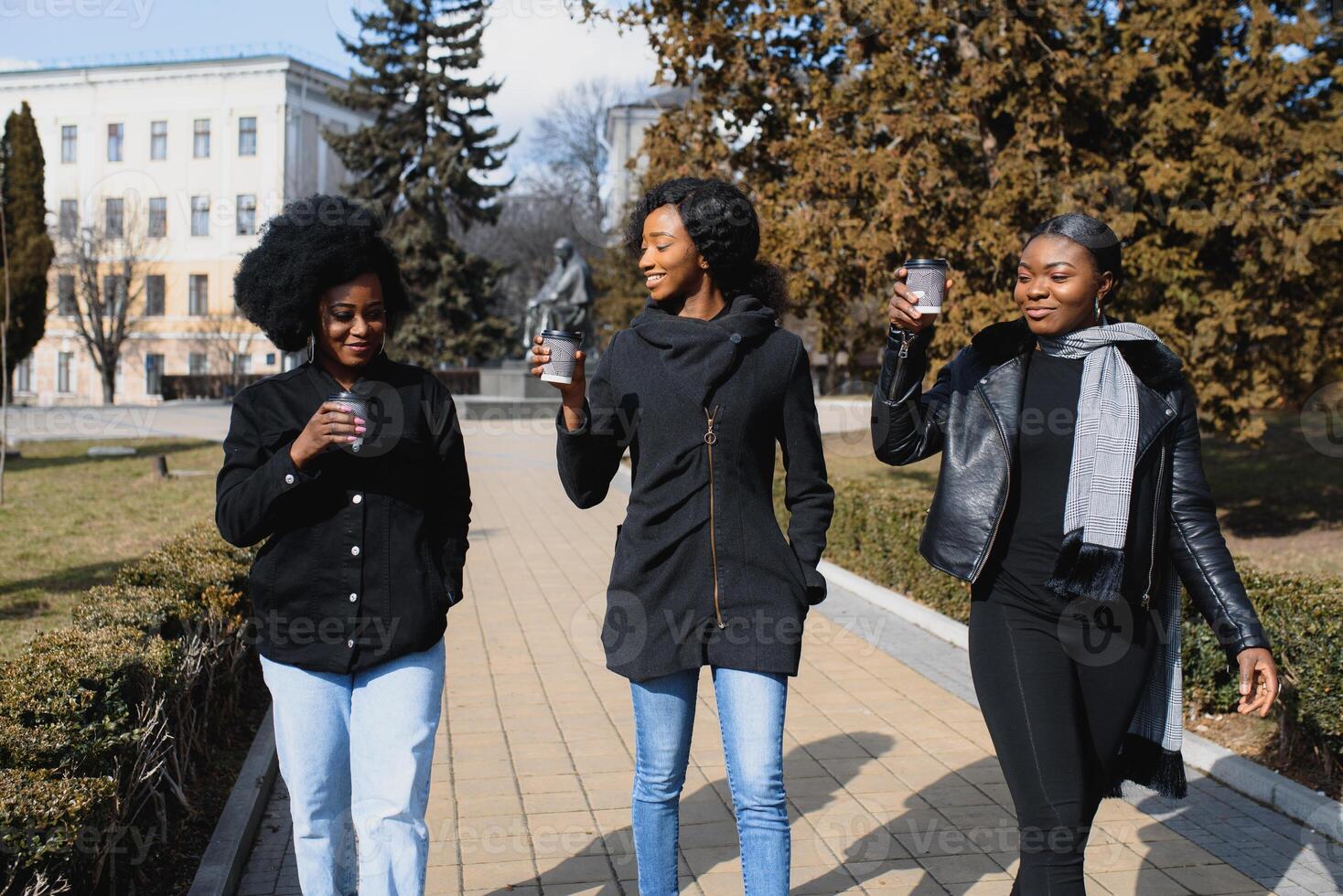 stylish african american girls drinking coffee on the street photo