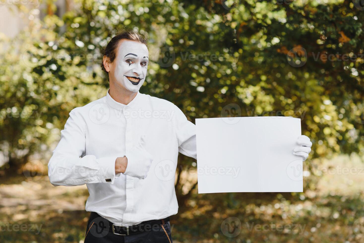 Your text here. Actors mimes holding empty white letter. Colorful portrait with green background. April fools day photo