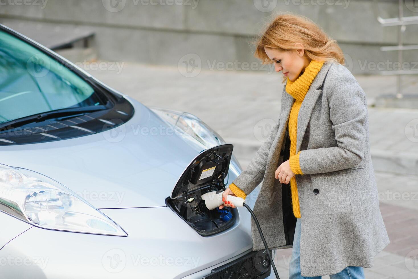 Woman charging electro car at the electric gas station. photo