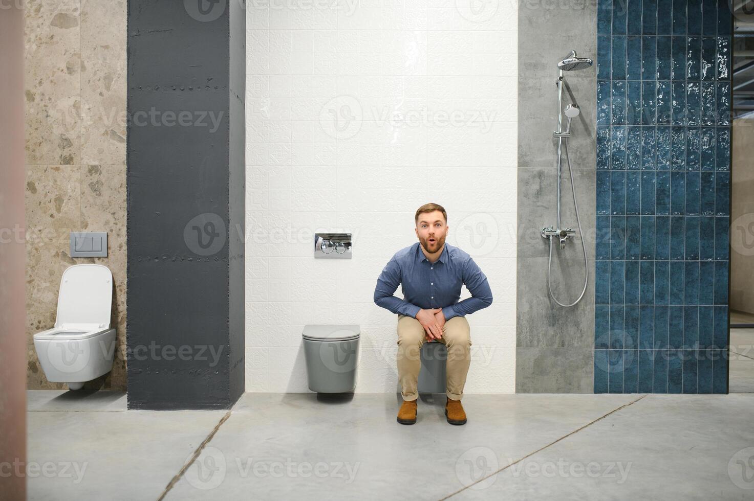 Man sitting on toilet in plumber store photo