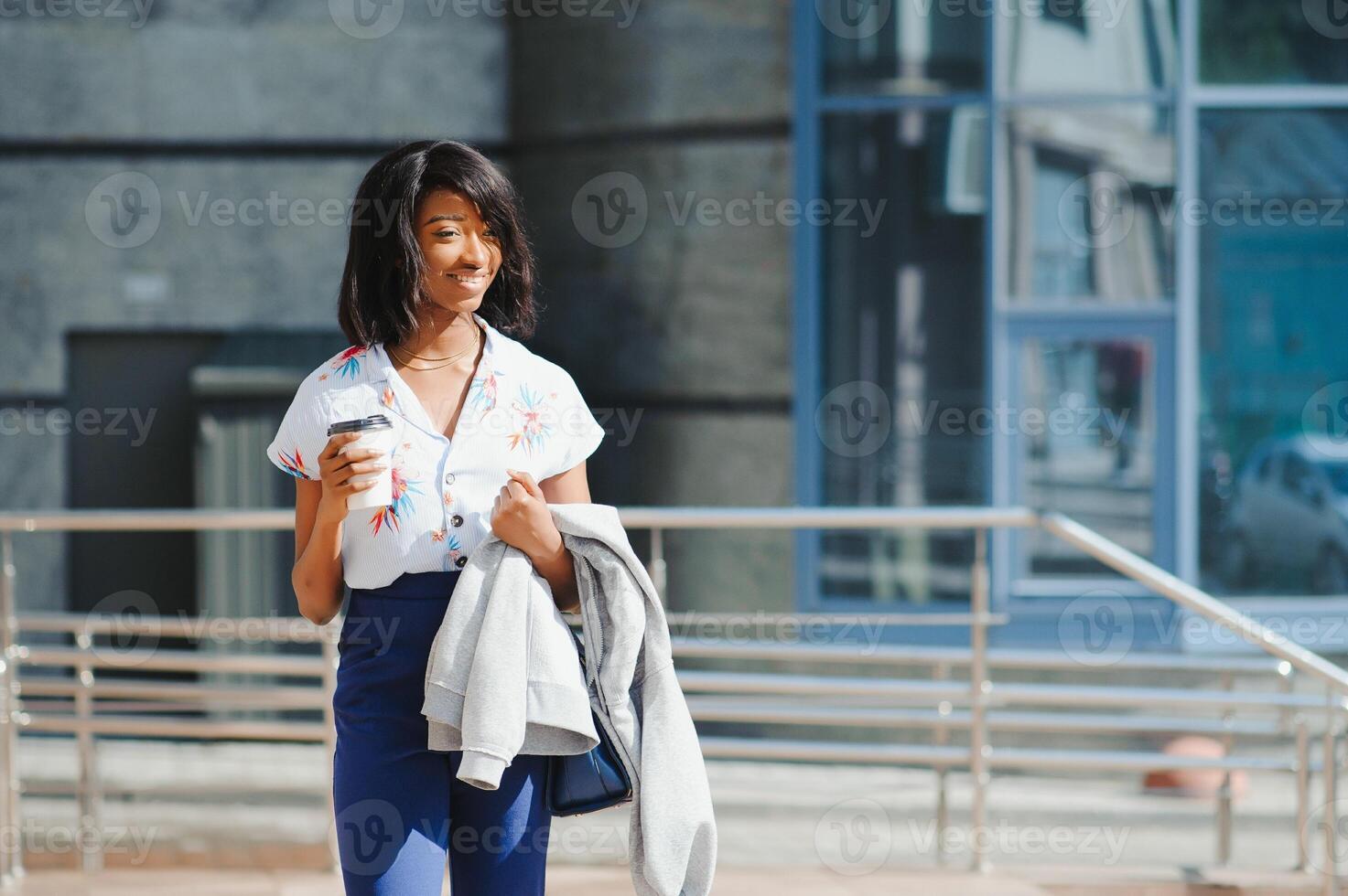 negocio y personas concepto - joven sonriente africano americano mujer de negocios con café taza en ciudad foto
