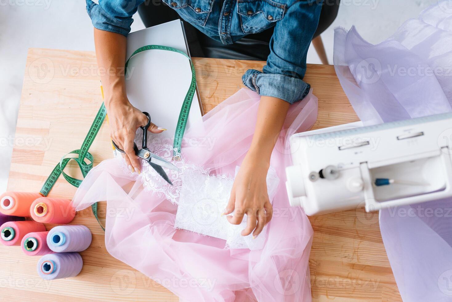 Working on new collection. New order. Female fashion designer works on the new clothes in the workshop photo