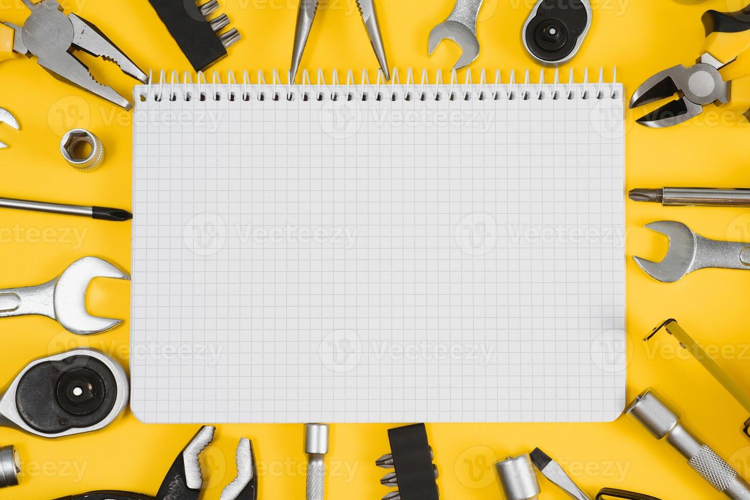 Tools top view on yellow background. Plier, open wrenches, screwdrivers and staple gun flat lay with copy space photo