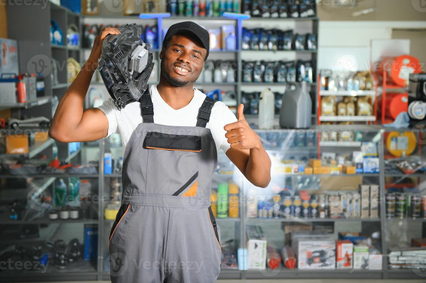 Portrait of a handsome african salesman in an auto parts store. The concept of car repair photo