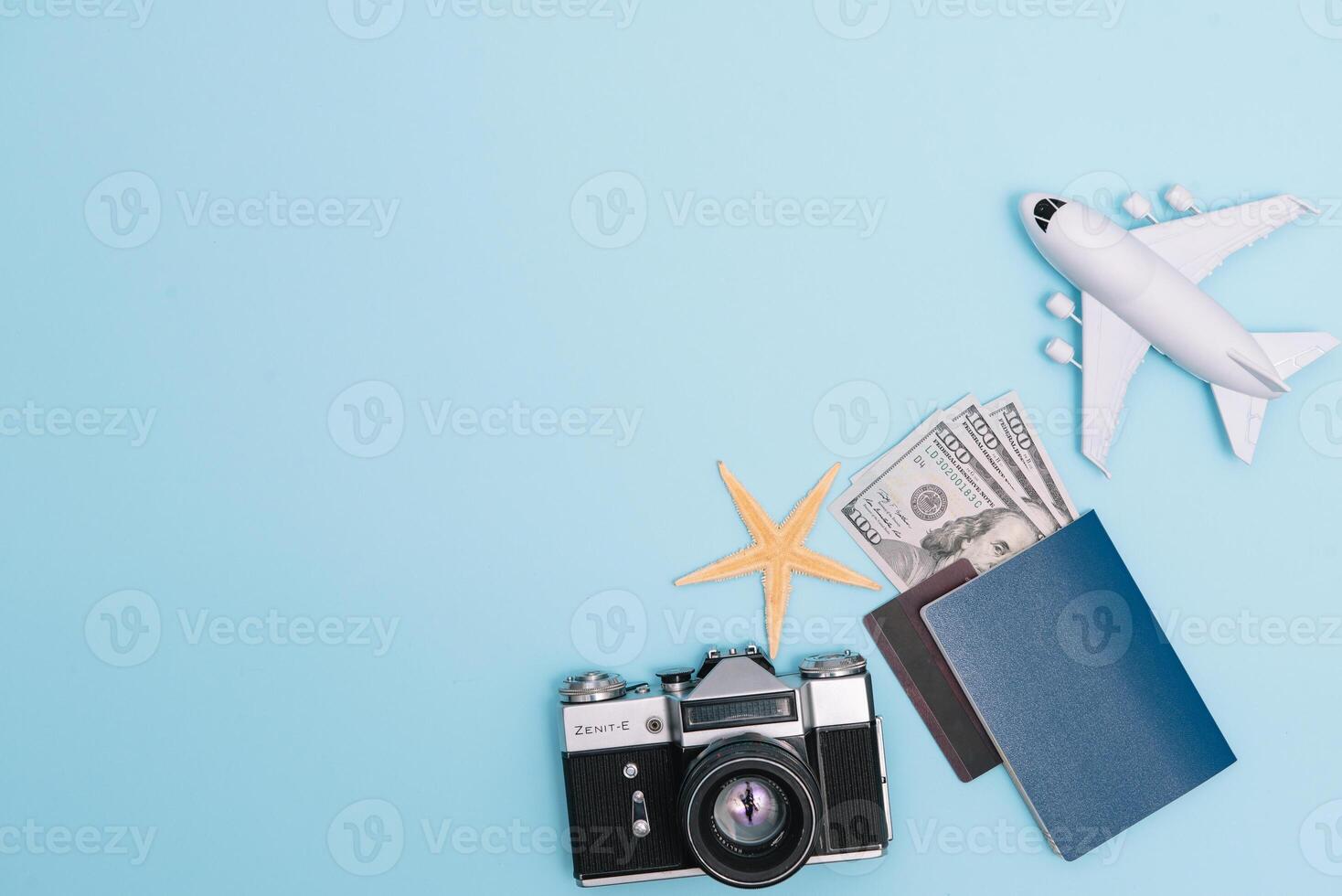 top view travel concept with retro camera films, smartphone, map, passport, compass and Outfit of traveler on blue background with copy space, Tourist essentials, vintage tone effect photo