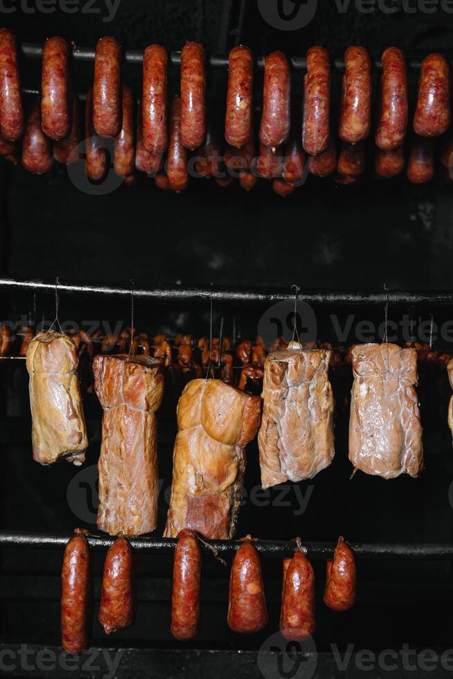 Smoked traditional smoked meat. A composition of smoked cold cuts on a black background. photo