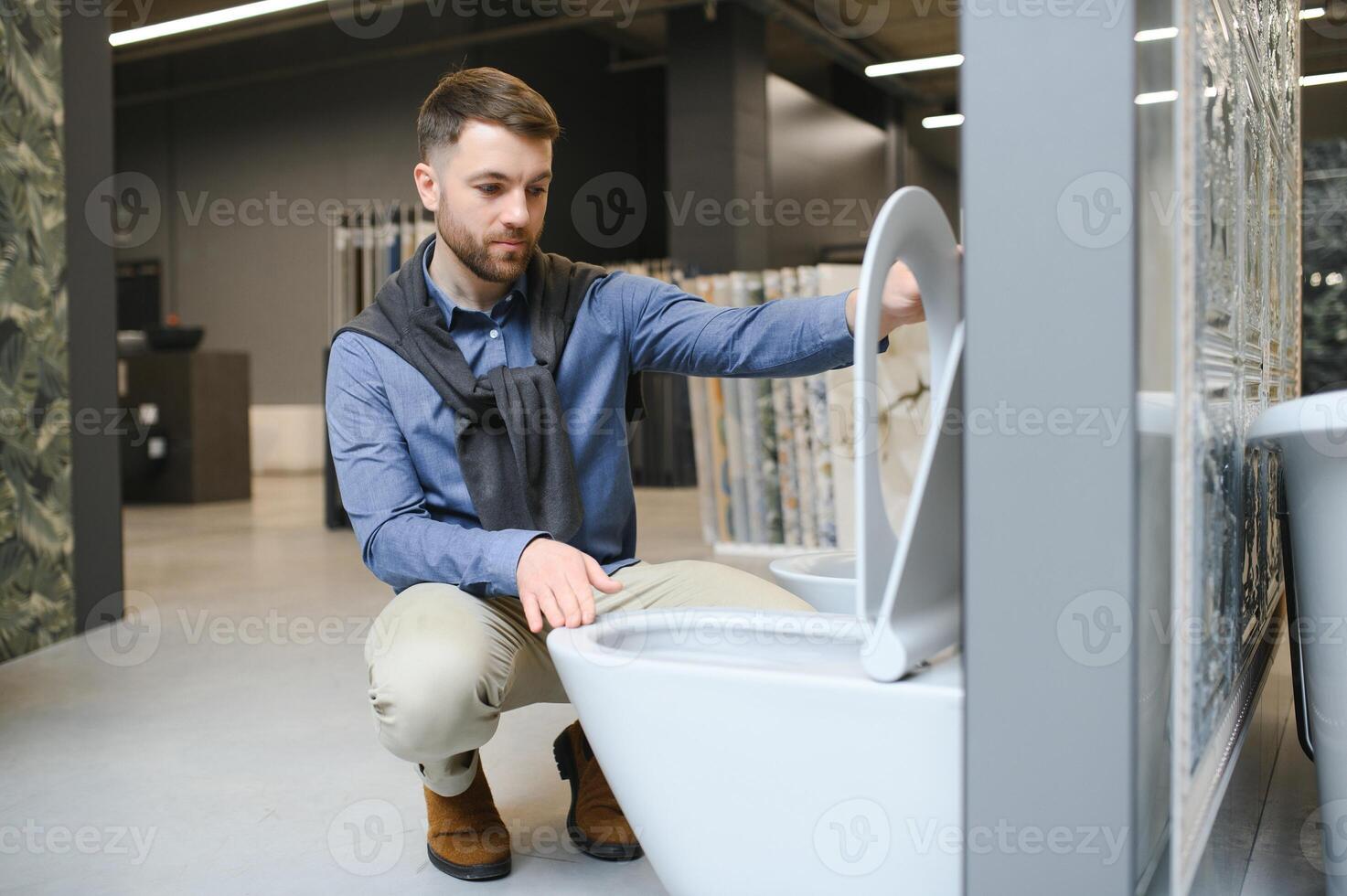 Man choosing home toilet in store photo