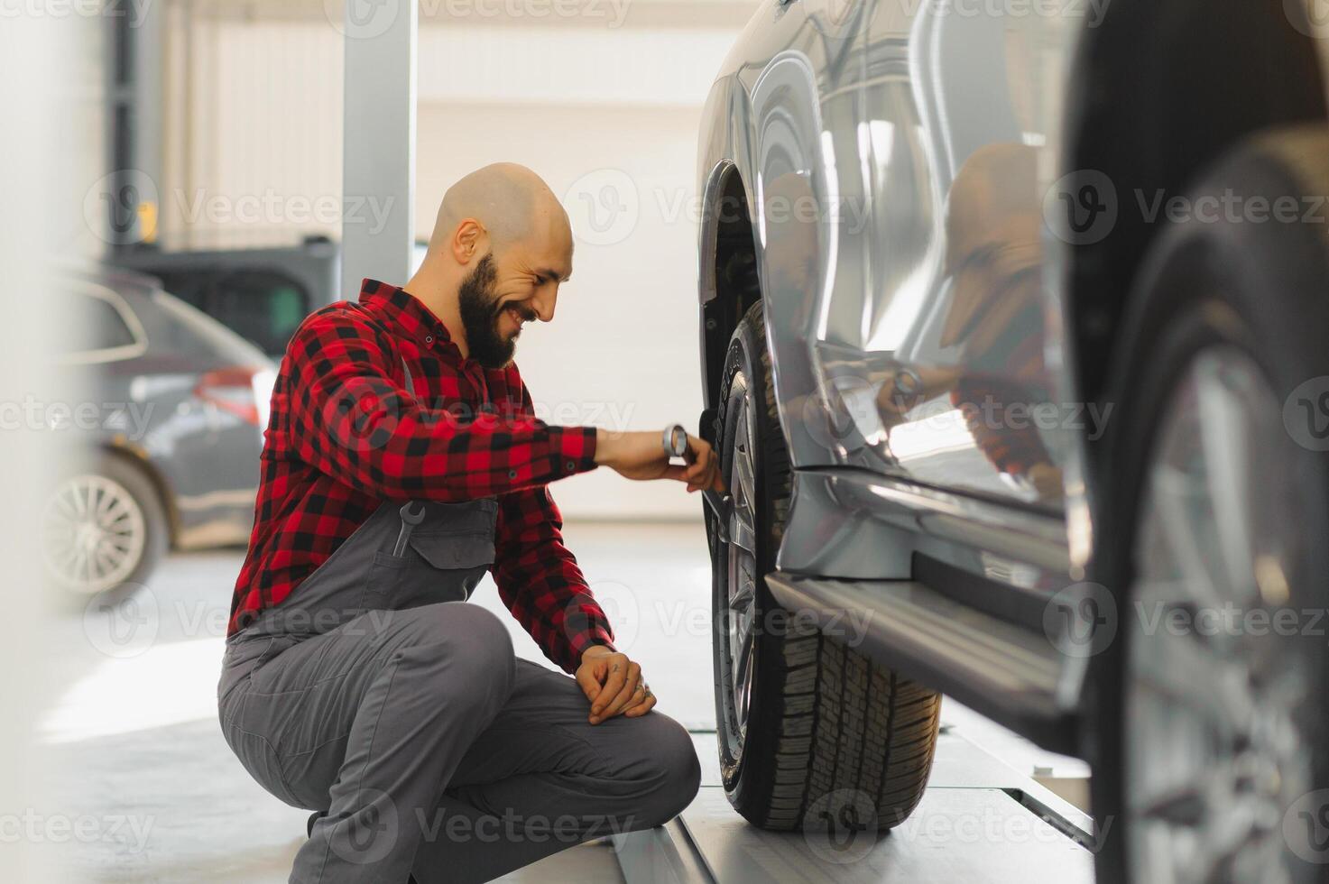 The hand of a car mechanic with a wrench in a combi zone near the car in the workshop photo
