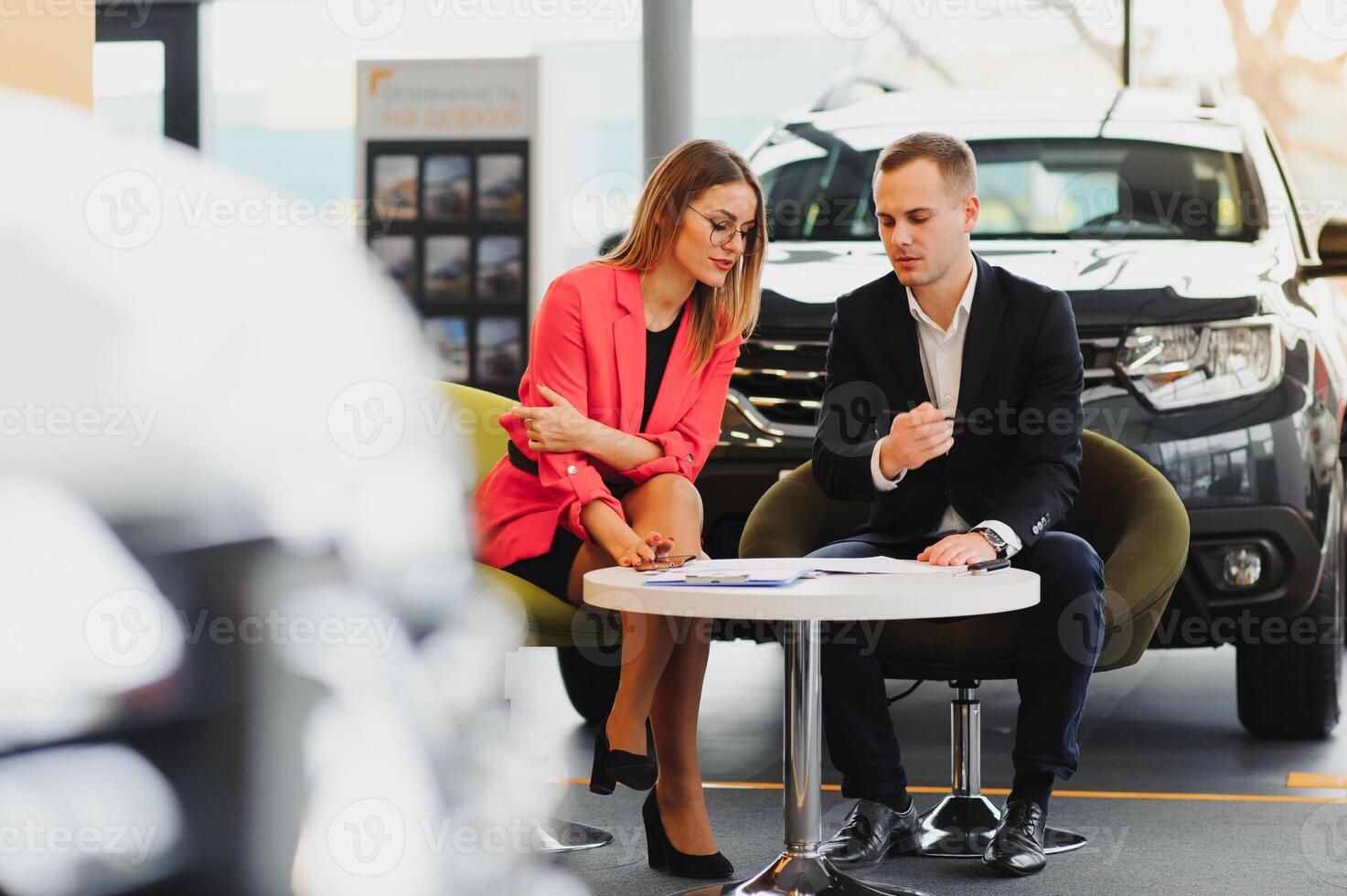 Beautiful young woman buys a car in the dealership saloon. photo