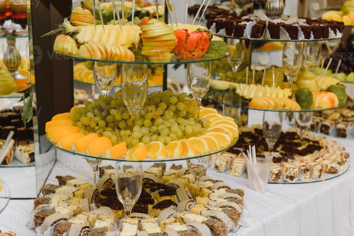 desserts with fruits, mousse, biscuits. Different types of sweet pastries, small colorful sweet cakes, macaron, and other desserts in the sweet buffet. candy bar for birthday photo