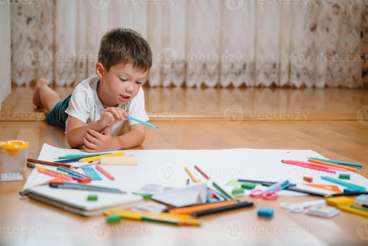 Kids drawing on floor on paper. Preschool boy and girl play on floor with educational toys - blocks, train, railroad, plane. Toys for preschool and kindergarten. Children at home or daycare. photo