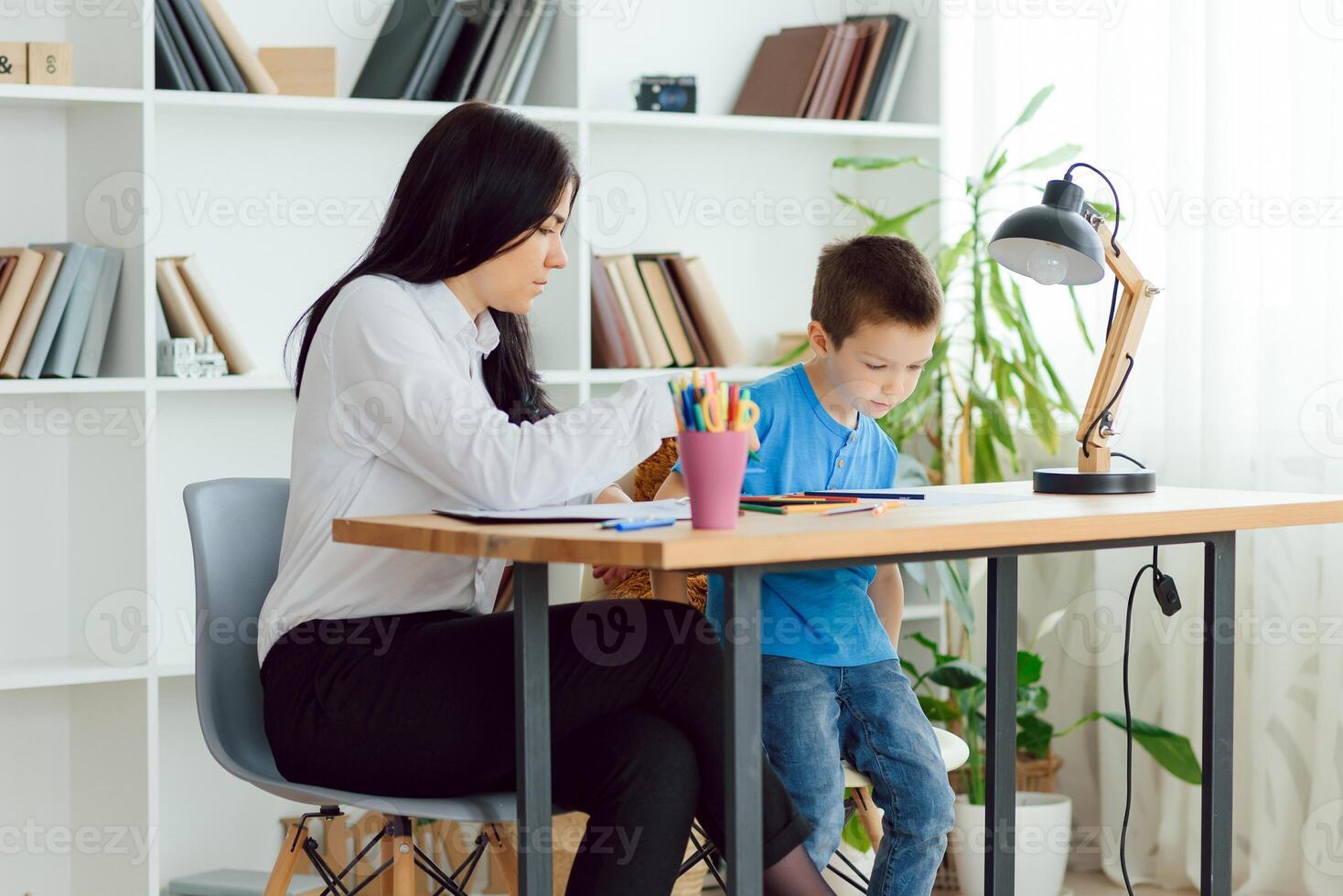 Child psychologist working with boy in office photo