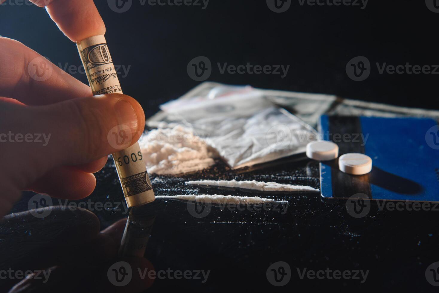 Cocaine drug powder bag and pile and pills on black background. photo