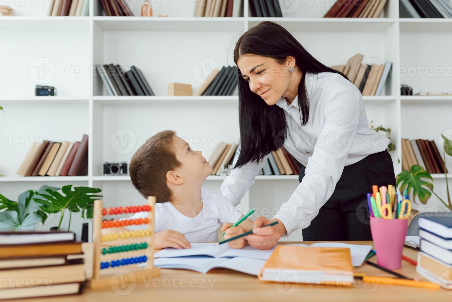 Portrait of pretty tutor and diligent pupil looking at each other while communicating photo
