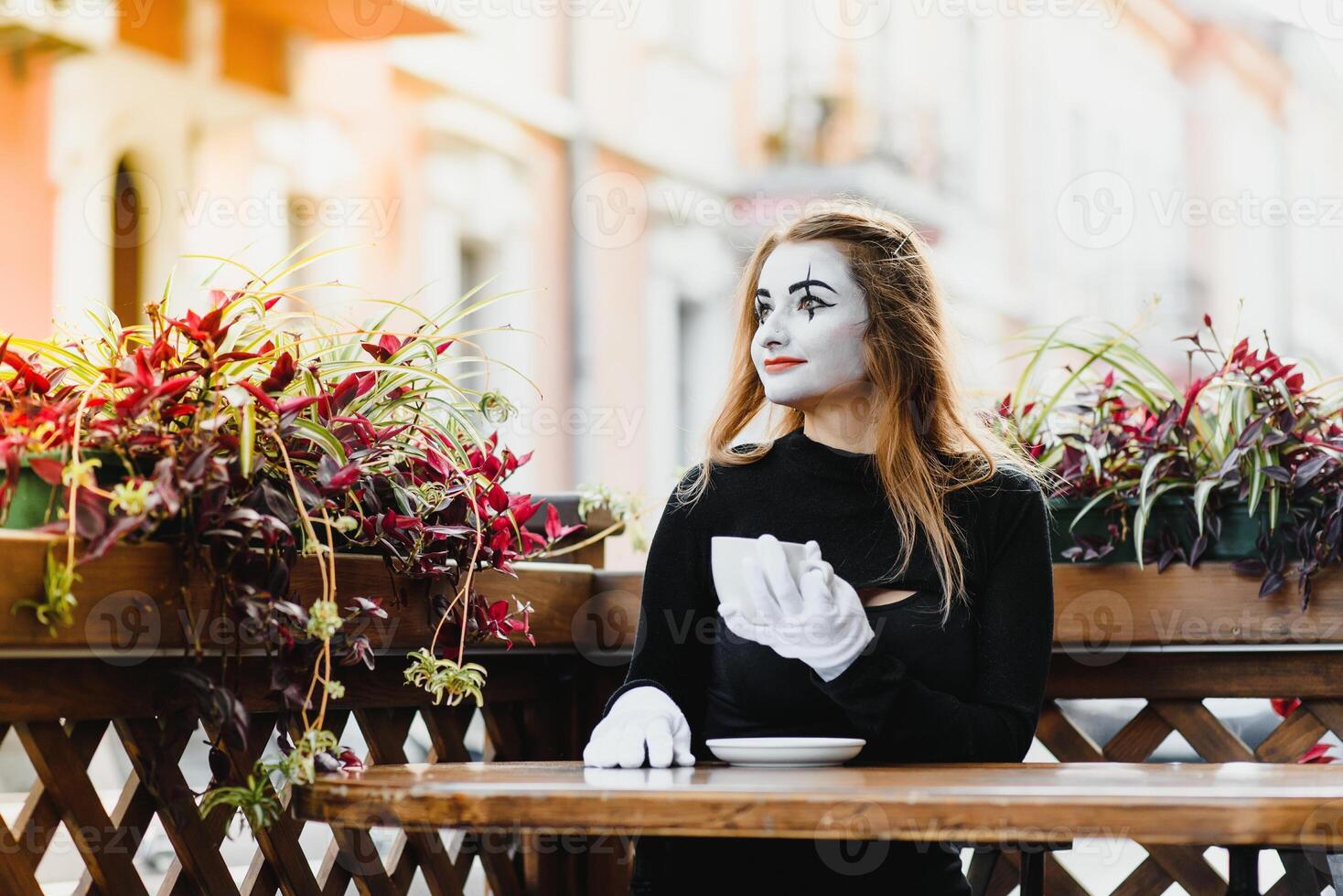 Mime comedian drinking coffee. girl mime drinks coffee in paris. photo