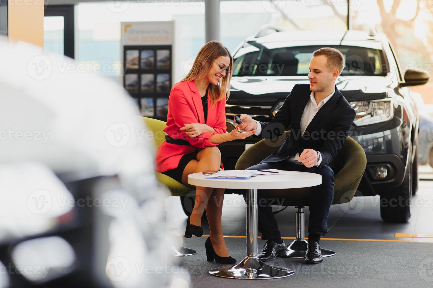 Beautiful young woman buys a car in the dealership saloon. photo