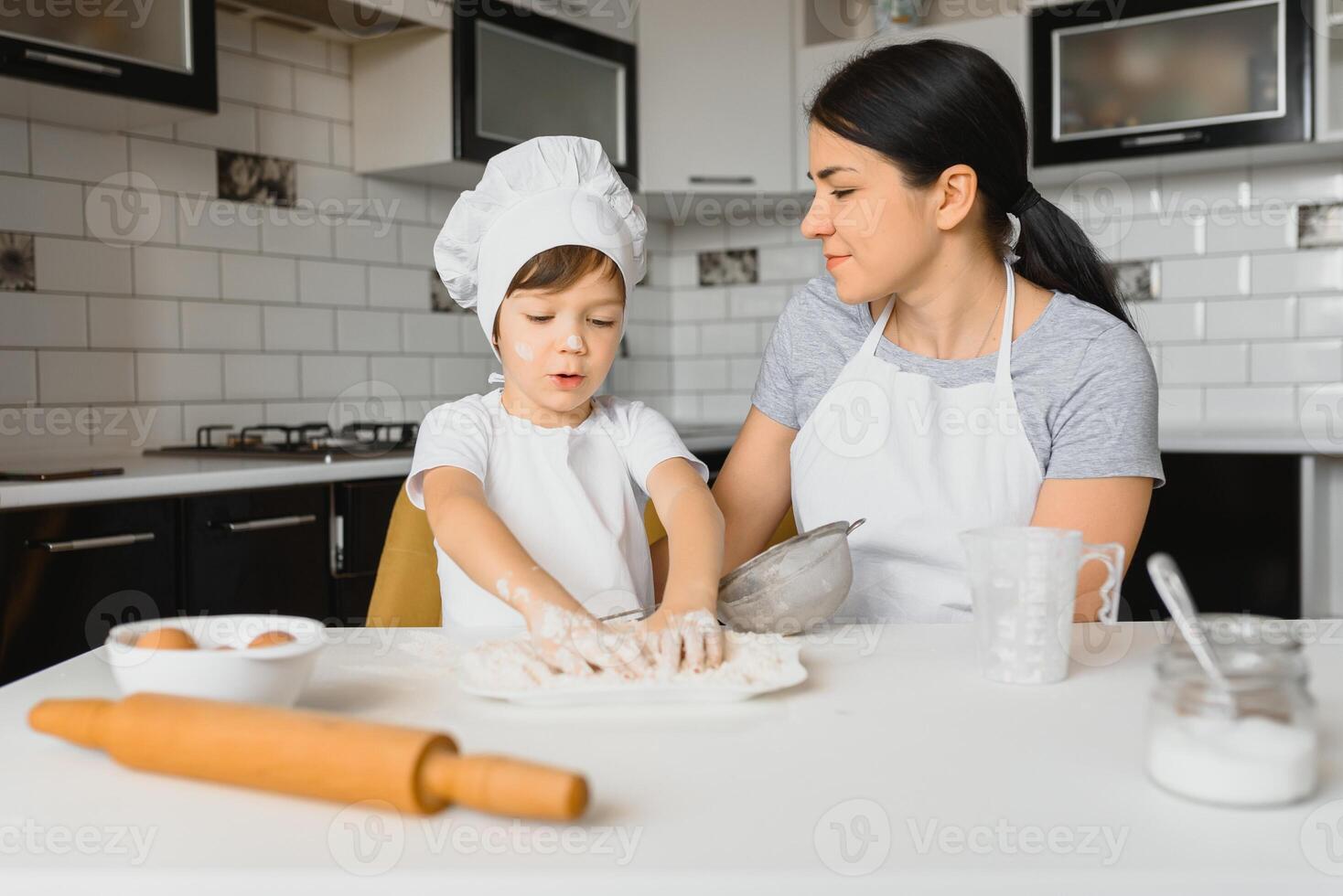 contento familia. madre enseñando su hijo cómo a Cocinando pastel menú en Mañana. sano estilo de vida concepto.. horneando Navidad pastel y cocinar concepto foto