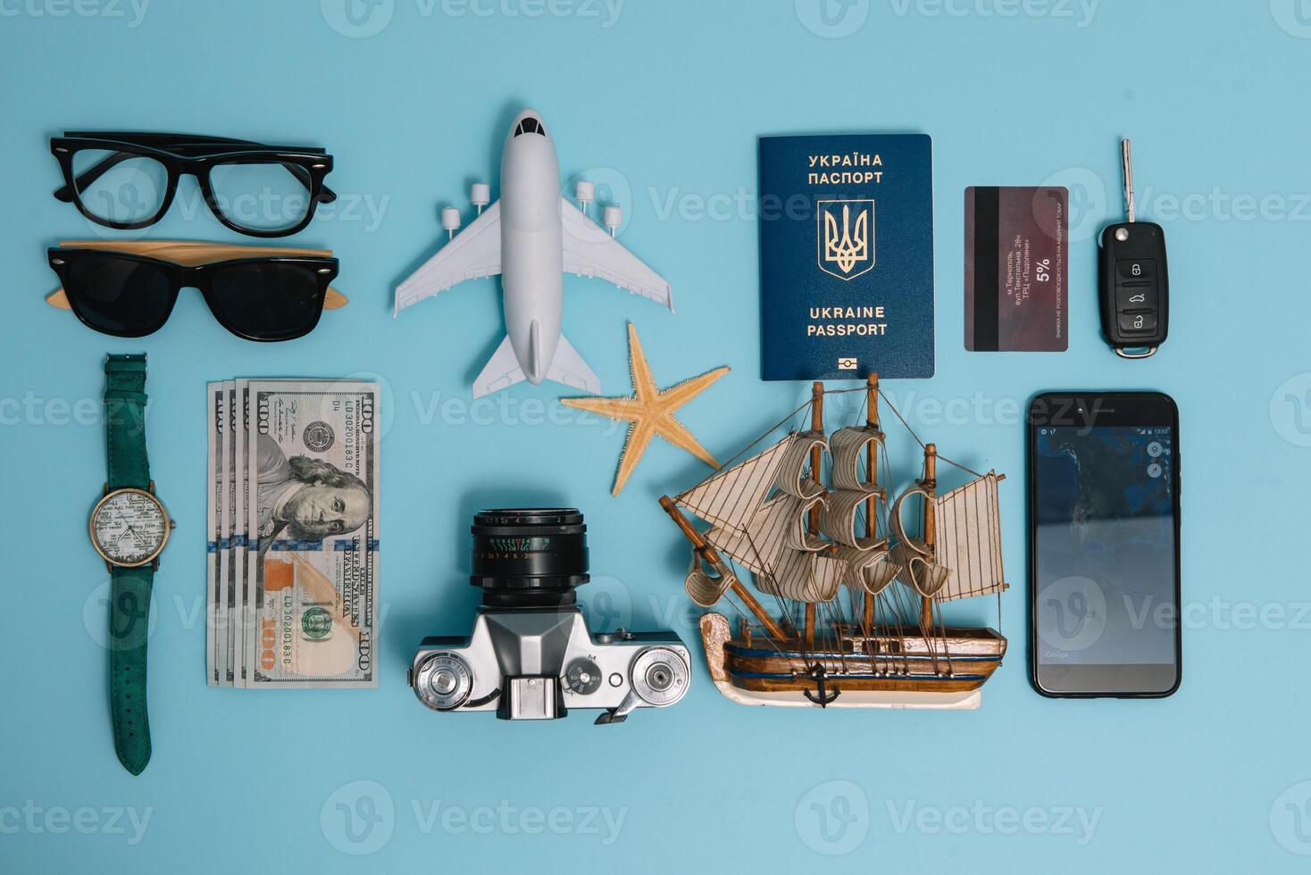 Preparation for Traveling concept, watch, airplane, money, passport, pencils, book, Photo frame, eyeglass on blue background with copy space.