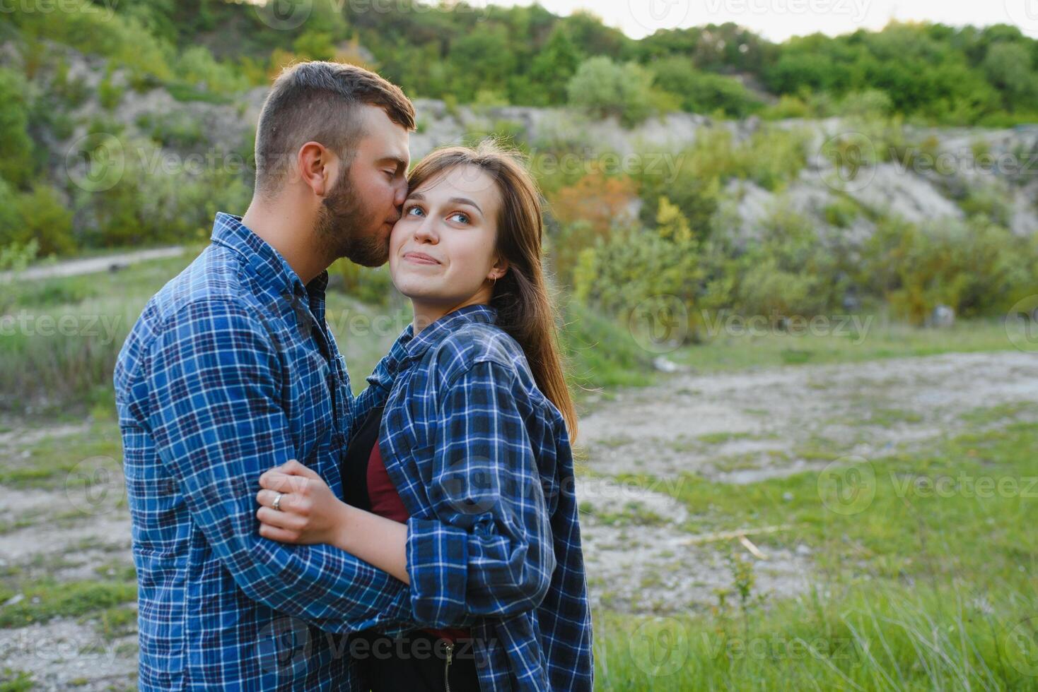 Couple enjoying beautiful views on the mountains, while traveling with backpacks in the mountains during the summer vacations photo