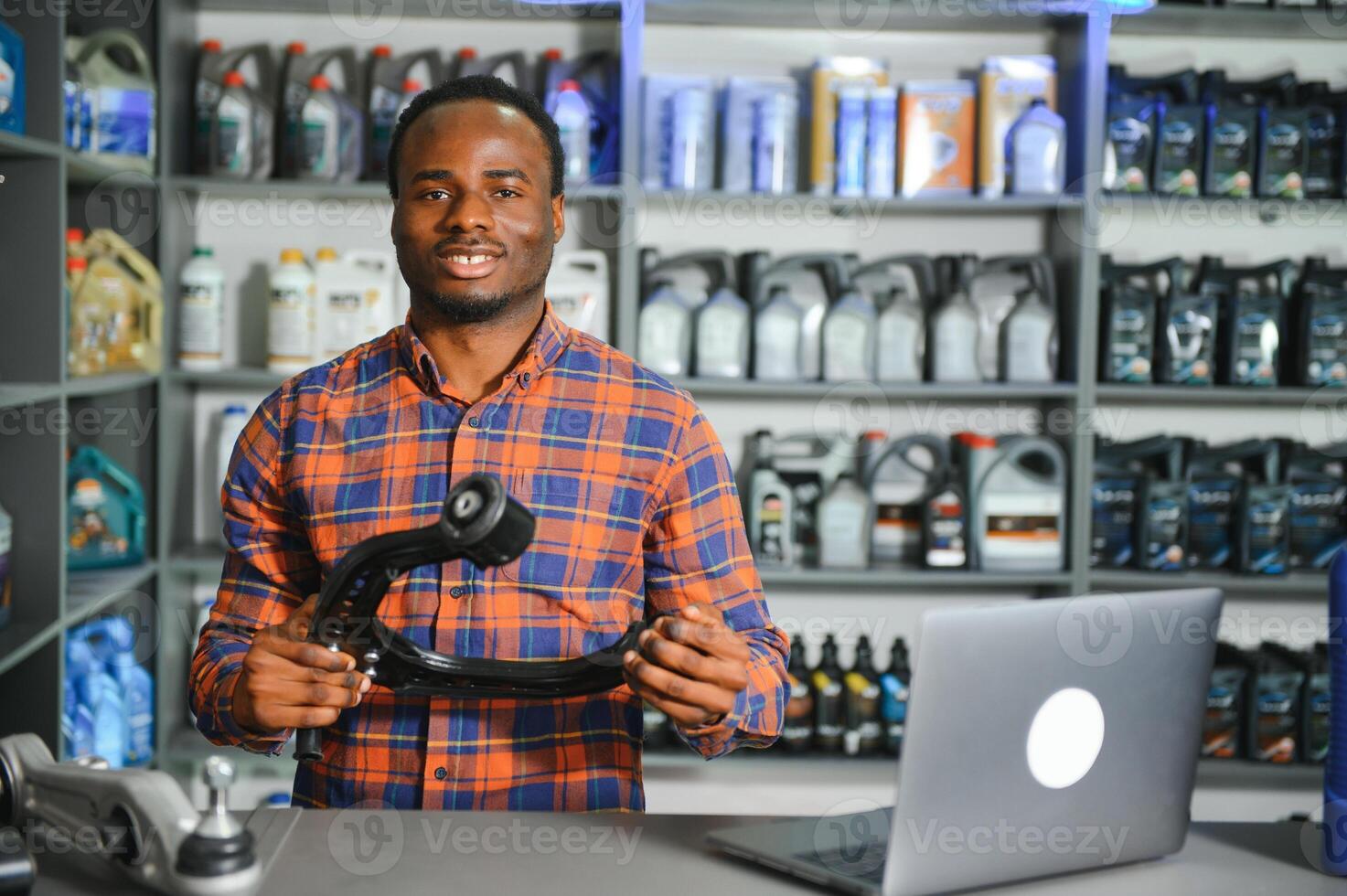 Portrait of a handsome african salesman in an auto parts store. The concept of car repair photo