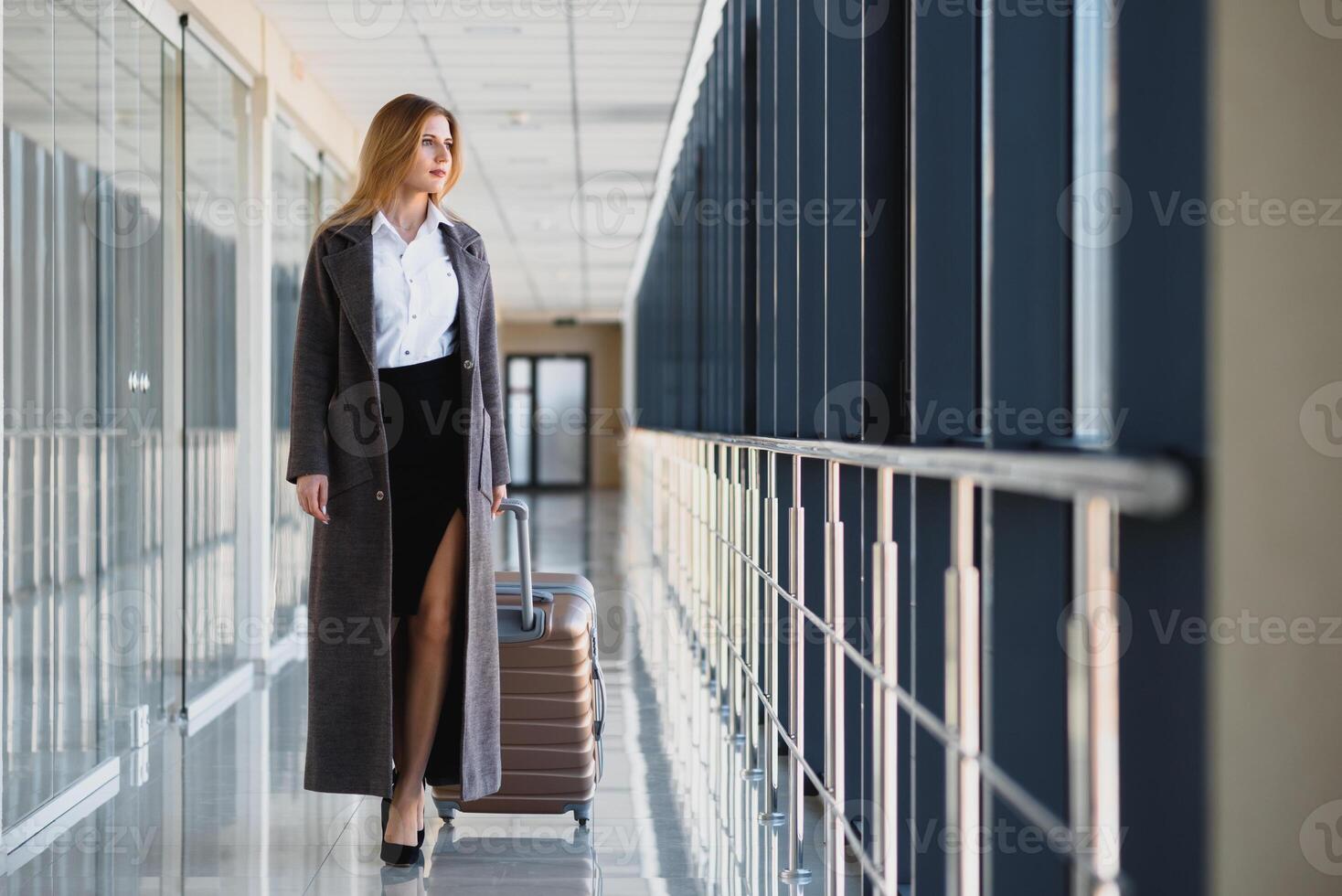 elegante mujer de negocios con equipaje a el aeropuerto. el concepto de negocio vuelos por avión foto