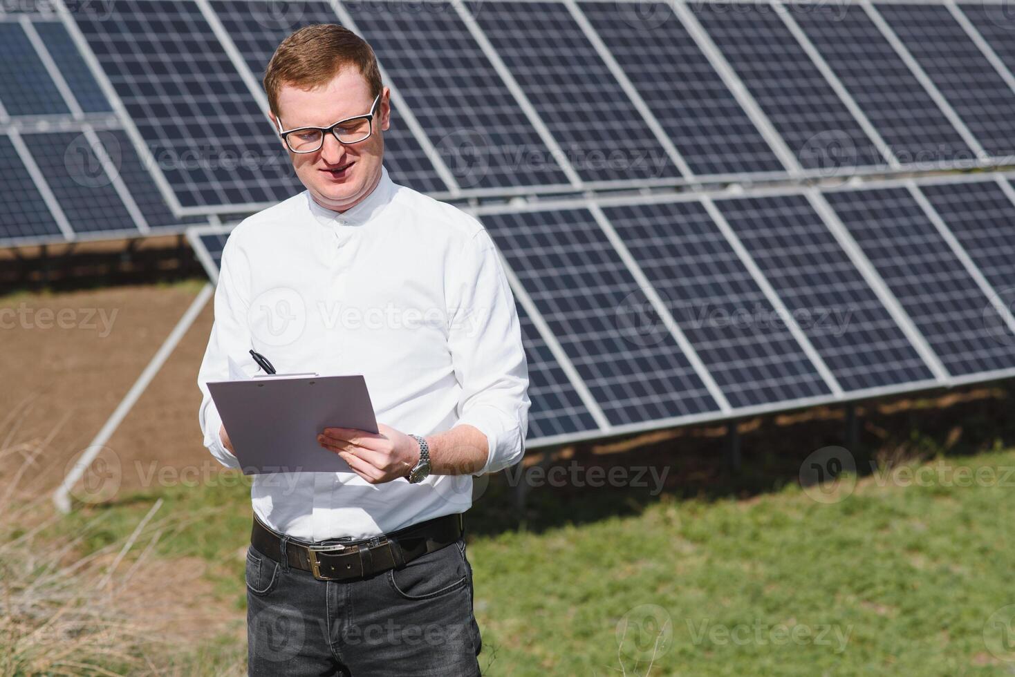 Engineer. Man near solar panel. Worker with a folder. photo