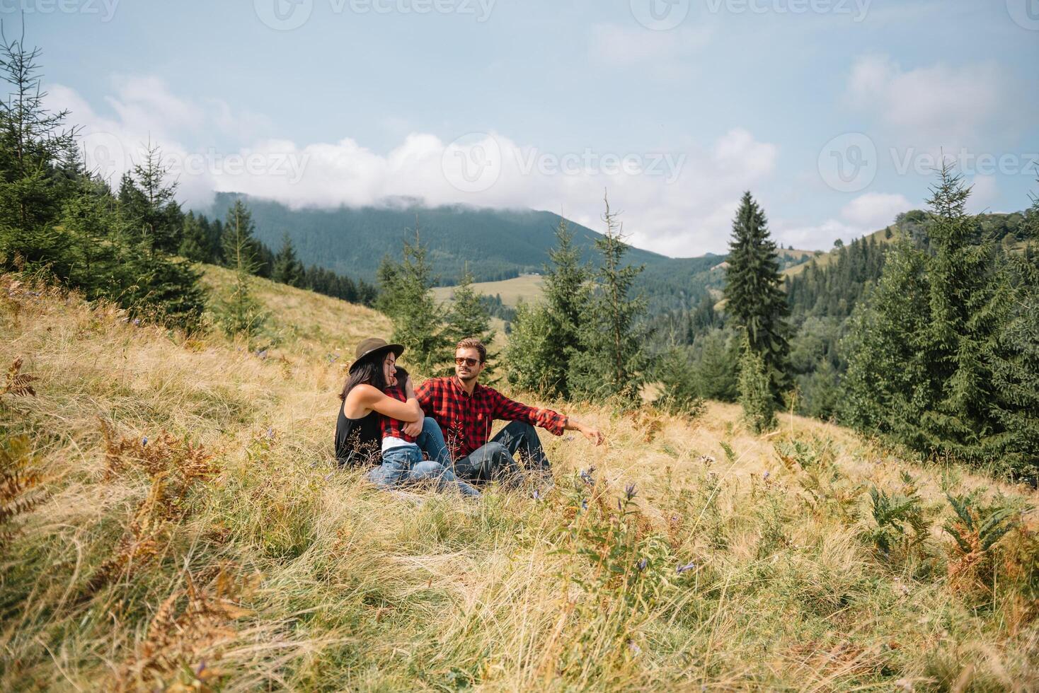 Family laying down the grass enjoying mountain view photo