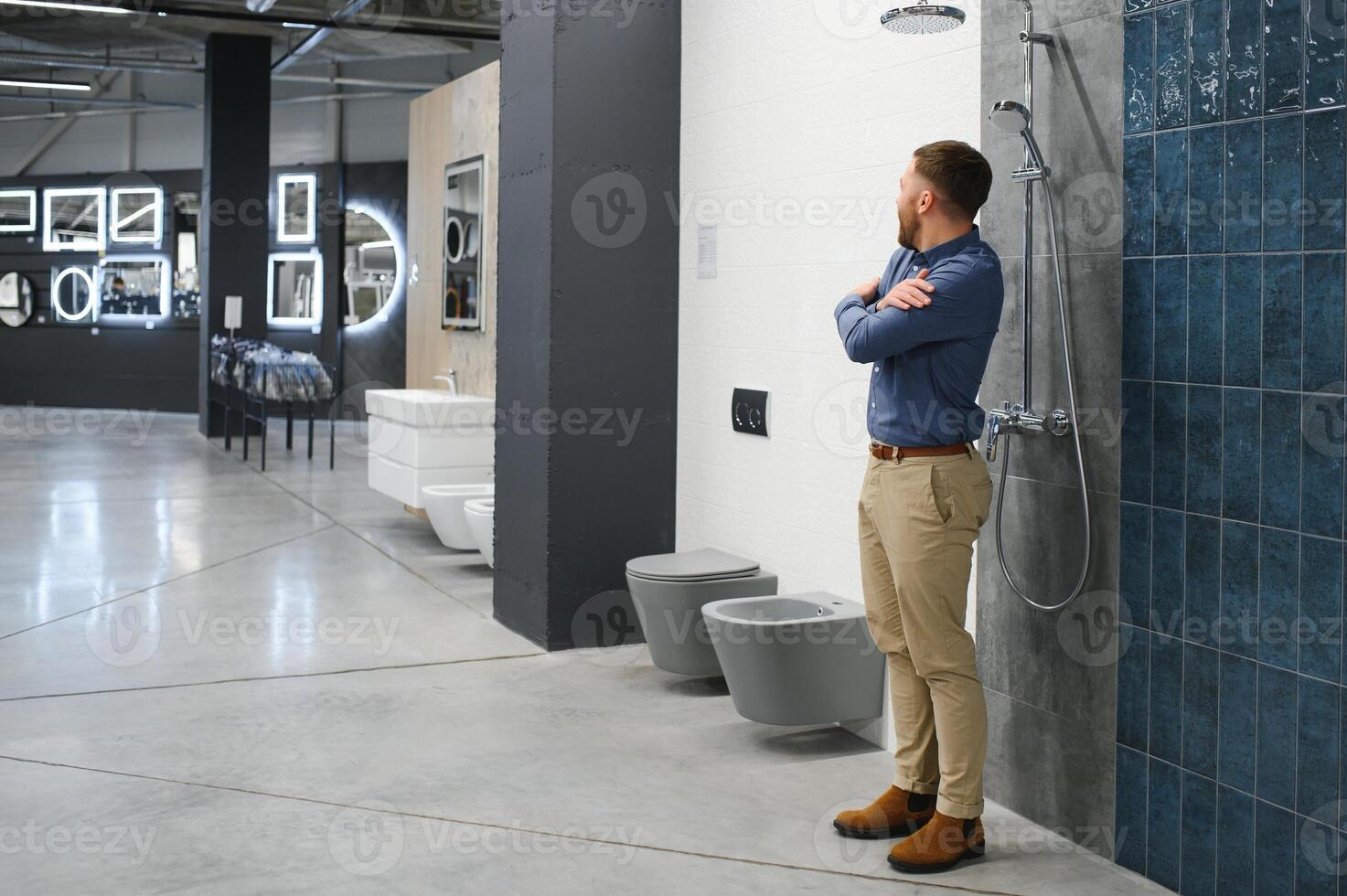 Playing with shower faucet. Man chooses a products in a sanitary ware store photo