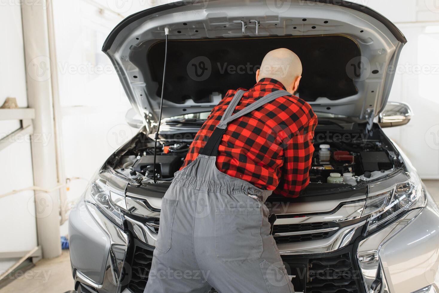 Mechanic working and holding wrench of service order for maintaining car at the repair shop photo