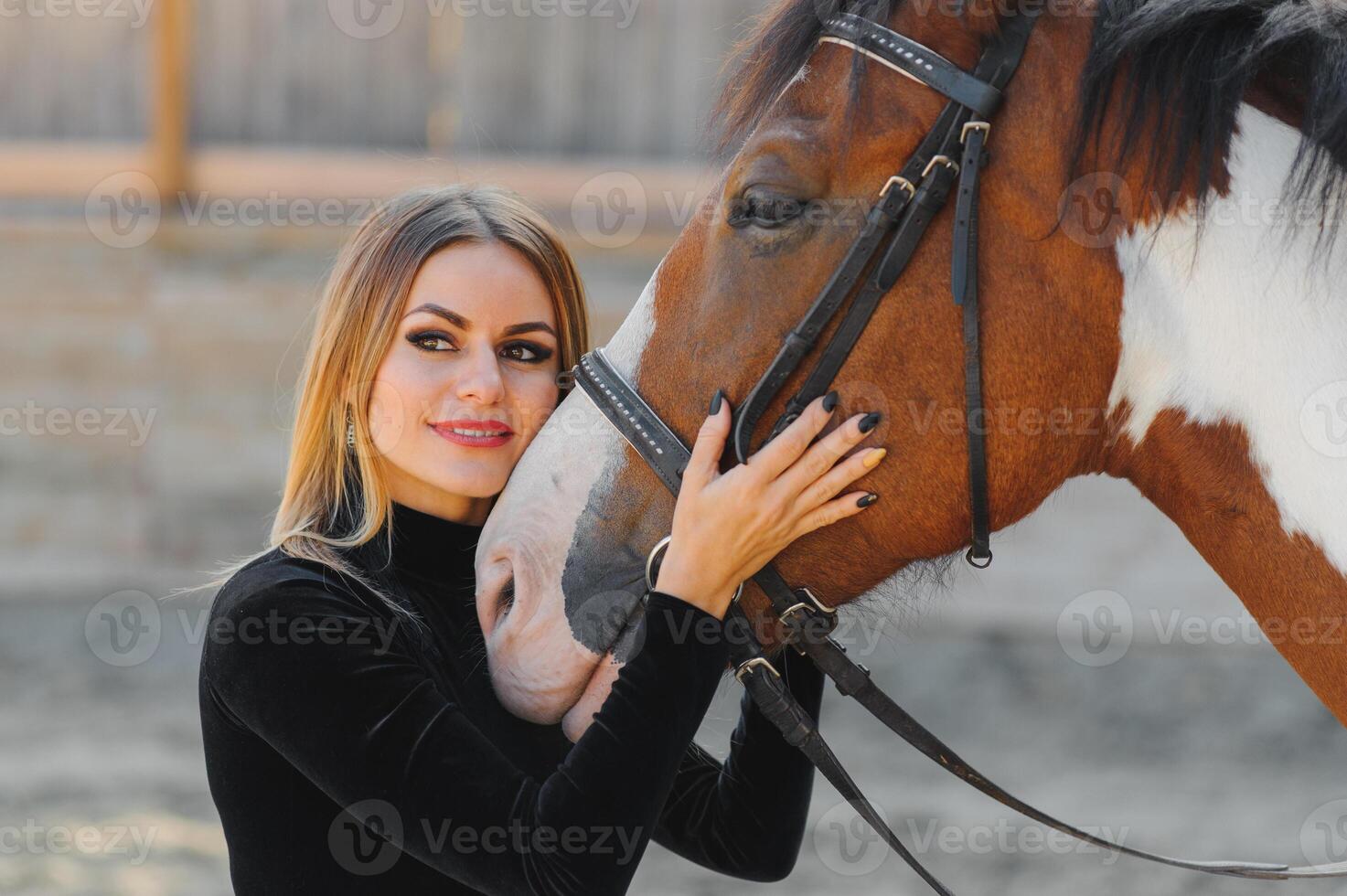 Portrait of young pretty cheerful woman with horse at summer photo