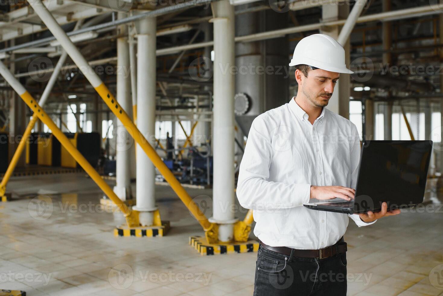 sonriente y contento empleado. industrial trabajador adentro en fábrica. joven técnico con blanco difícil sombrero. foto