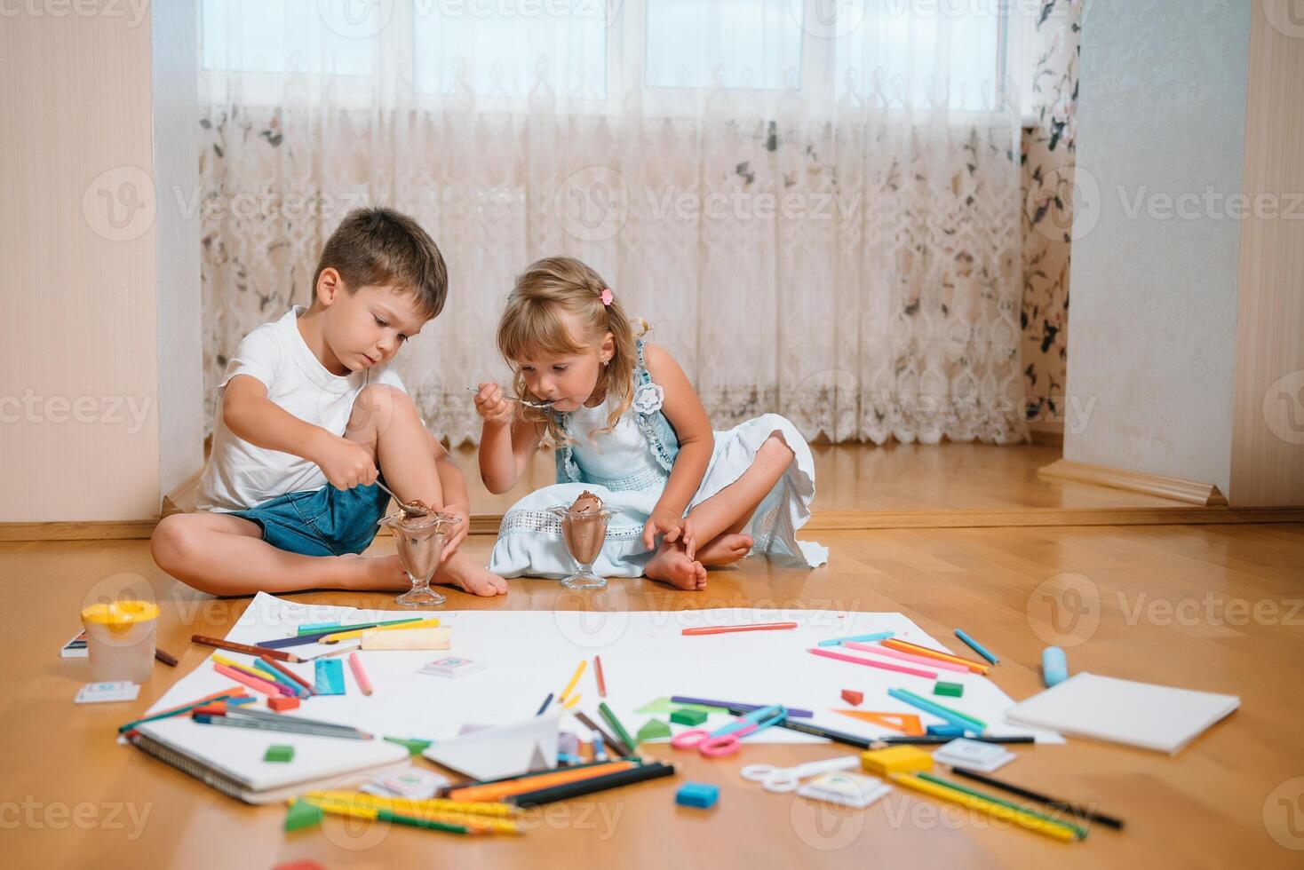 Kids drawing on floor on paper. Preschool boy and girl play on floor with educational toys - blocks, train, railroad, plane. Toys for preschool and kindergarten. Children at home or daycare. photo