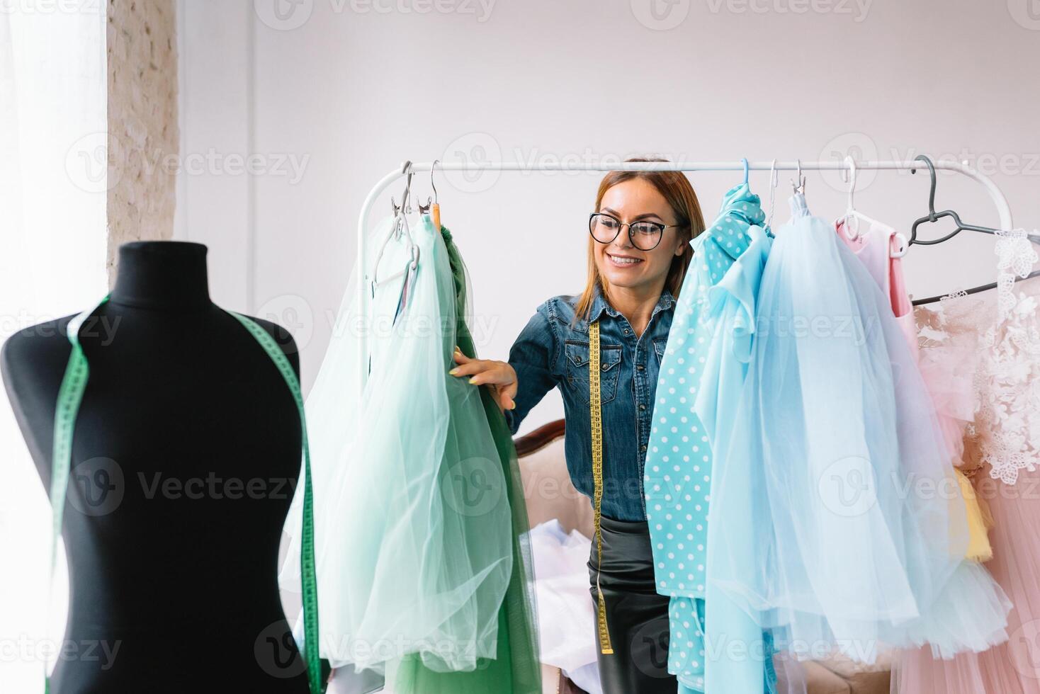 Working on new collection. New order. Female fashion designer works on the new clothes in the workshop. photo