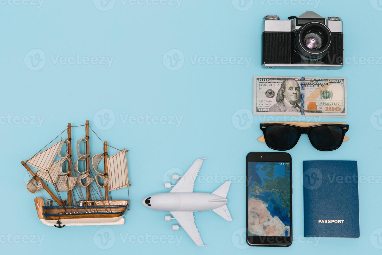 Preparation for Traveling concept, watch, airplane, money, passport, pencils, book, Photo frame, eyeglass on blue background with copy space.