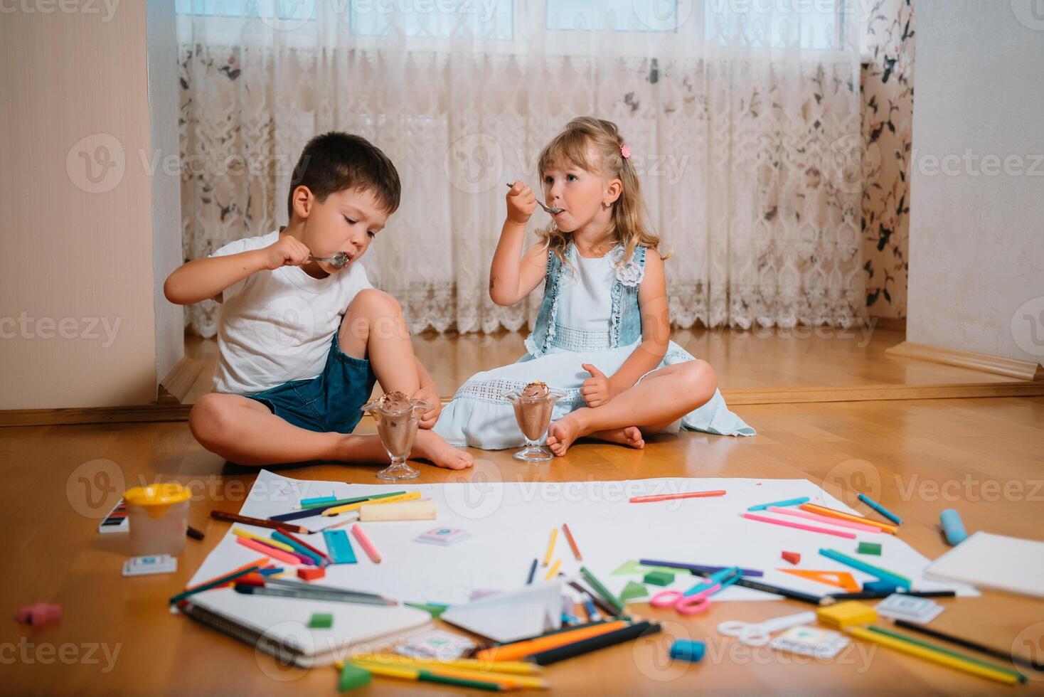 Kids drawing on floor on paper. Preschool boy and girl play on floor with educational toys - blocks, train, railroad, plane. Toys for preschool and kindergarten. Children at home or daycare. photo