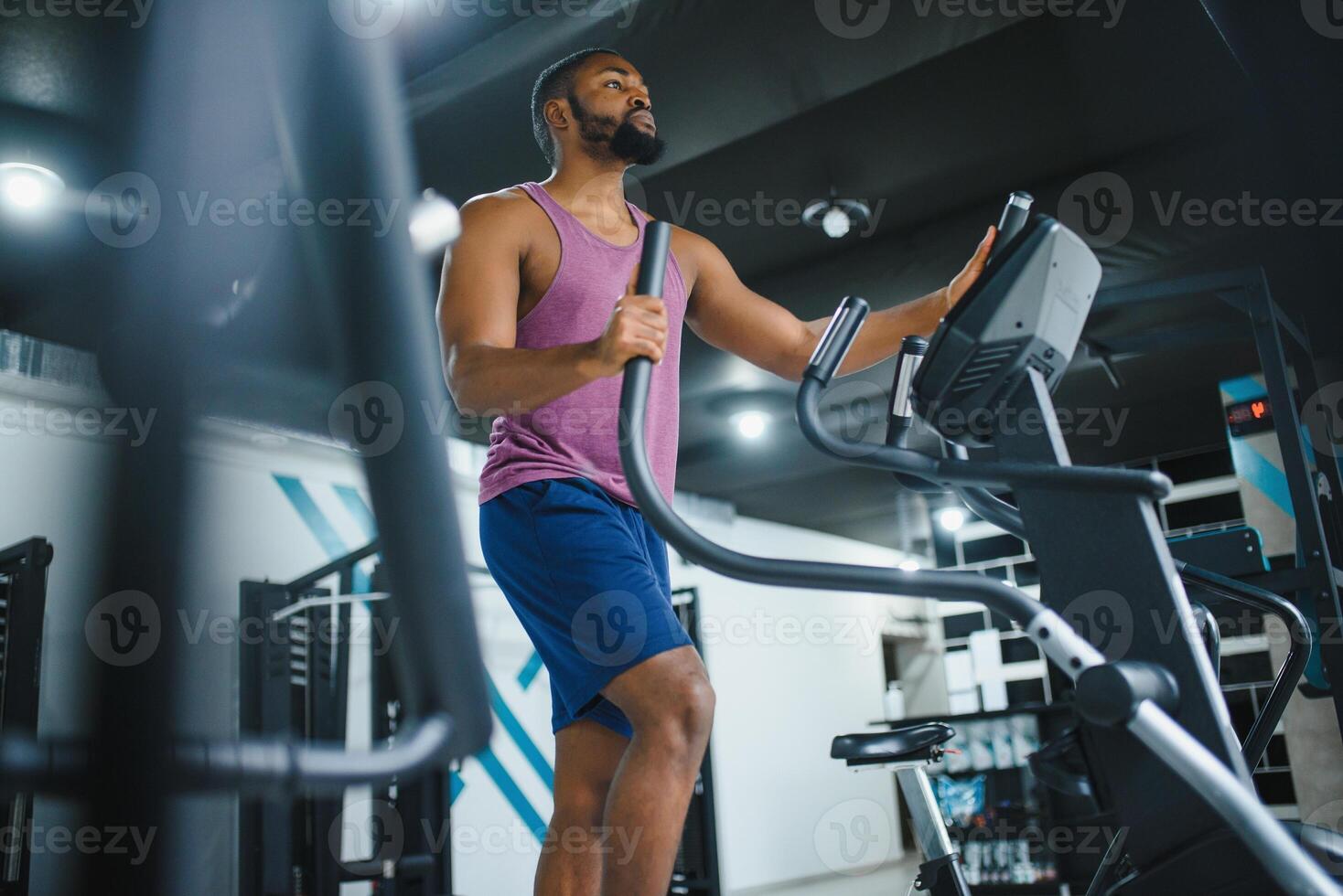 Weight training African doing bodybuilding in gym. photo